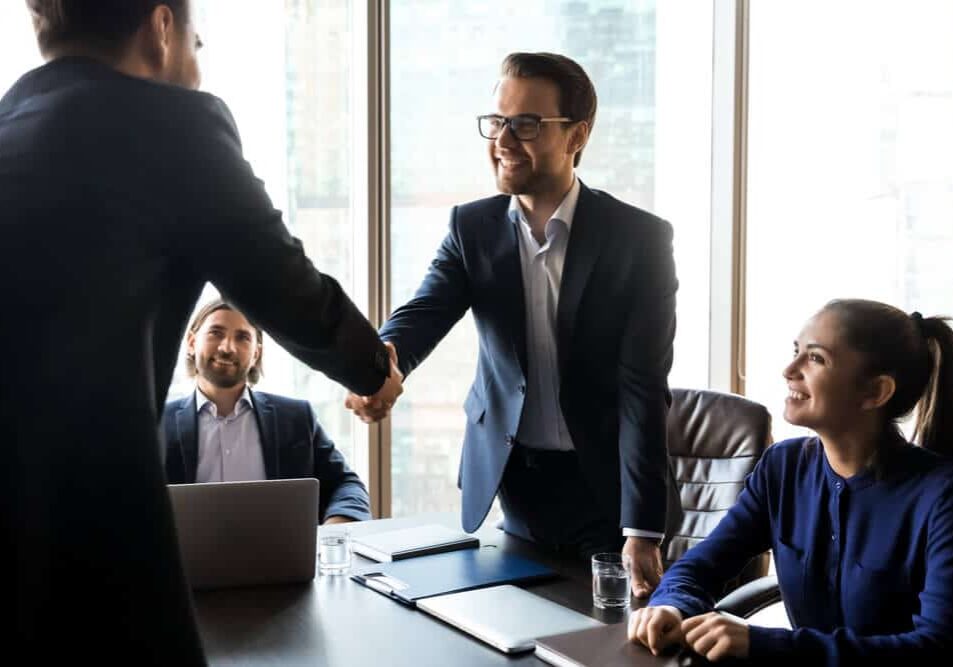 businessman in suit shaking hand of applicant at interview
